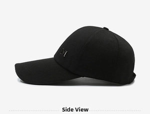 Detail of black baseball cap side with silver metal M logo and twill cotton fabric