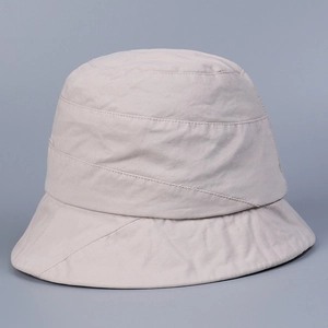 Detail shot of beige cotton bucket hat stitching and premium washed fabric texture
