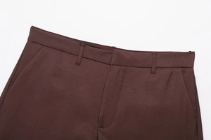 Detailed view of dark brown casual trousers showing belt loops and side pockets