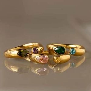 Macro shot of 18k gold plated open rings featuring colorful teardrop birthstones