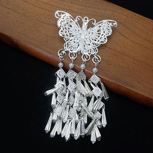 Silver butterfly hair clip with tassel and pearls on a premium dark wooden background