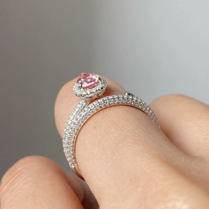 Silver ring with pink oval gemstone and sparkling diamond accents on model hand
