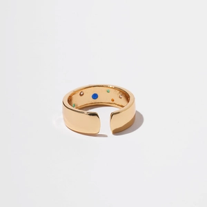 Detailed macro view of gold open ring featuring colorful enamel dot inlay on inner band