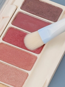 Macro detail of shimmer eyeshadow powder texture with a professional gradient makeup brush