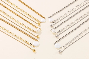 Detail of gold and silver heart shell pendant necklaces with varied chain textures