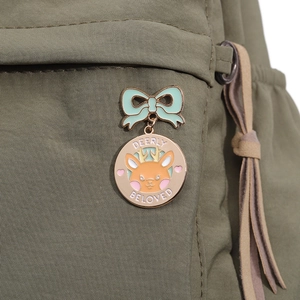 Detail der Emaille-Anstecknadel mit Hirsch, grüner Schleife auf einer Stofftasche
