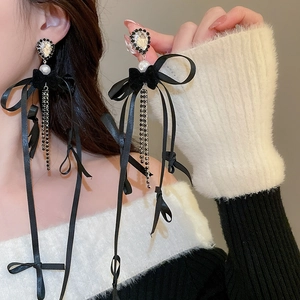 Détail de boucles d'oreilles nœuds avec cristaux et pampilles de perles élégantes