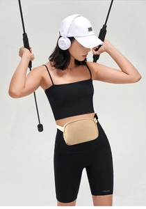 Close-up of minimalist light beige sports waist bag with adjustable strap on model