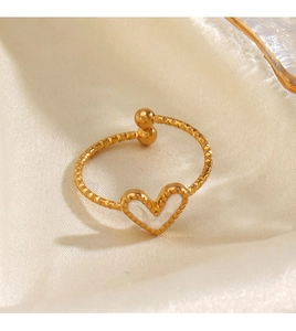 Detail of a gold open heart ring with white inlay on a premium beige silk background