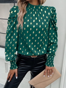 Detailed view of dark green shirt with gold polka dots and elegant puff sleeve cuff elastic