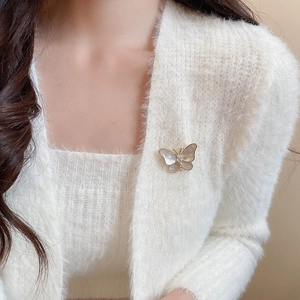 Detailed macro view of a 14K gold plated butterfly brooch with iridescent shell wings