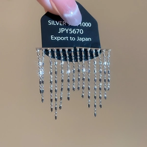 Detailed macro of silver long tassel earrings with shimmering multiple chain links