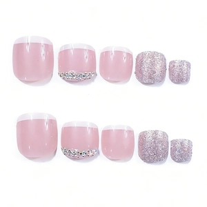 Detail of French tip press-on toenails featuring pink glitter and rhinestone accents
