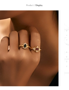 Detail of vintage style gold rings featuring oval blue and rectangular red gemstones
