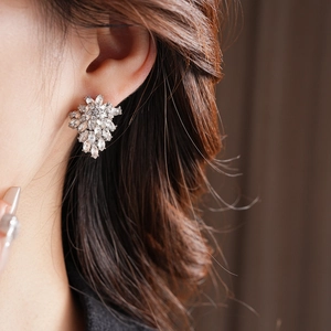 Detail of marquise-cut crystal leaf cluster earrings worn by model for elegant style