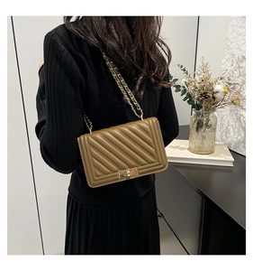 Detail of olive green quilted leather handbag with chain strap and square metal lock