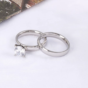 Polished silver stainless steel couple rings set with a round cubic zirconia stone