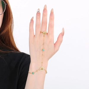 Detail of 18k gold plated slave bracelet featuring turquoise beads and heart charms