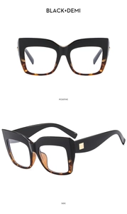 Detail of black and demi cat-eye frames with elegant gold square metal hardware