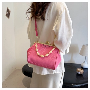Detailed view of pink pleated shell bag with pearl handle and detachable crossbody strap