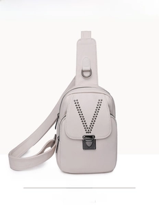 Détail frontal du sac de poitrine en cuir véritable avec rivets en V et boucle métal