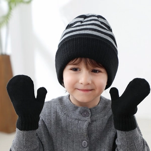 Detailed close-up of knit winter set for kids with striped beanie and ribbed black mittens