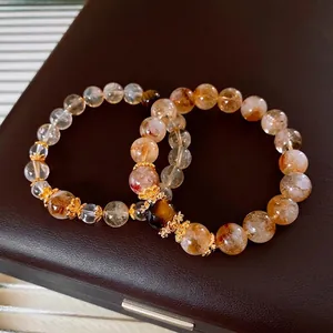 Tiger eye and yellow crystal beaded bracelet set with gold floral spacers on jewelry box