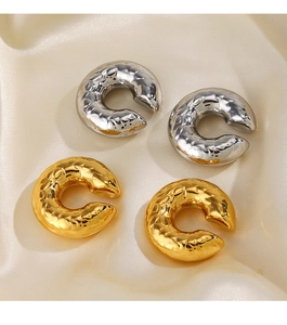 Detail of 18K gold and silver plated textured hollow ear cuffs on silk fabric