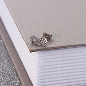 Macro detail of silver infinity stud earring with sparkling cubic zirconia stones
