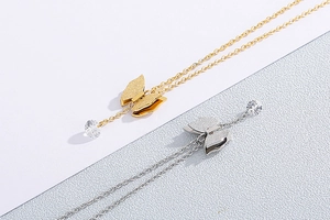 Detail of butterfly necklace set with rhinestone drops in gold and silver plating