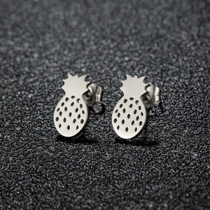Macro detail of silver pineapple stud earrings with hollow textured metal finish