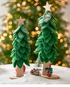Macro shot of forest green felt Christmas trees with wooden bases on a snowy surface