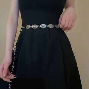 Detailed view of silver butterfly metal waist chain with textured oval links on black dress