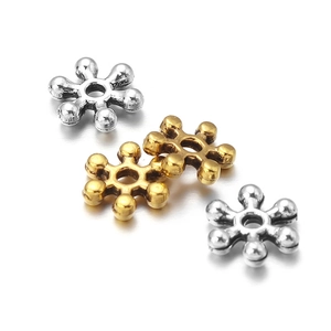Detailed view of 7mm snowflake spacer beads in vintage gold and silver alloy finishes