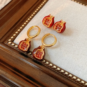 Detailaufnahme von Vintage-Granatapfel-Zirkon-Ohrringen auf einem Retro-Holzrahmen