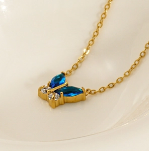 Vue macro du collier en acier inoxydable 18K doré avec pendentif papillon en zircon bleu