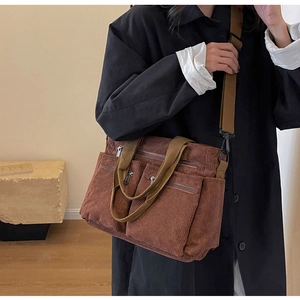 Detailed texture of brown corduroy crossbody bag with adjustable straps and metal zippers
