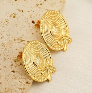 Gros plan de boucles d'oreilles nœud plaquées or 18 carats au design chapeau de paille