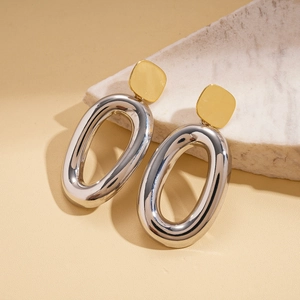 Detail of 18k gold plated geometric earrings on a white stone display stand