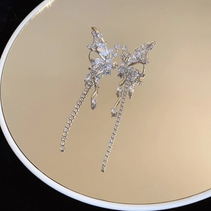 Detailed view of silver butterfly long tassel earrings with sparkling zircon on a gold base
