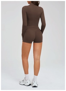 Vista posteriore del set yoga da donna con top a maniche lunghe marrone e pantaloncini