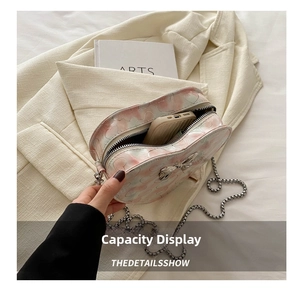 Detail showing the internal storage space of the pink heart pattern chain crossbody bag