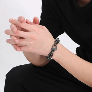 Close-up of a rugged gunmetal grey titanium curb chain bracelet on a male wrist
