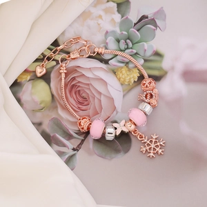 Rose gold snake chain bracelet with pink glass beads and sparkling snowflake charms