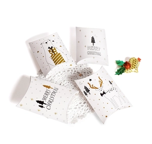 Detailed view of white Christmas pillow boxes with gold reindeer and tree patterns