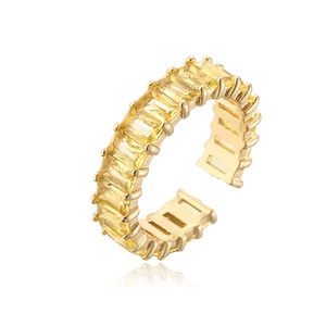 Close-up of gold-plated open ring featuring baguette-cut yellow zircon stones