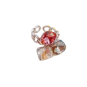 Silver chain ring with large square red and champagne zircon crystals on white background