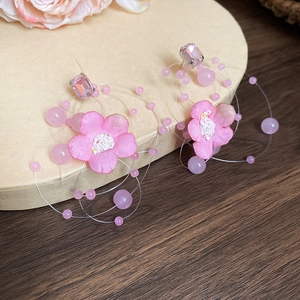 Macro detail of handmade pink fabric flower earrings with crystal stud and beaded petals