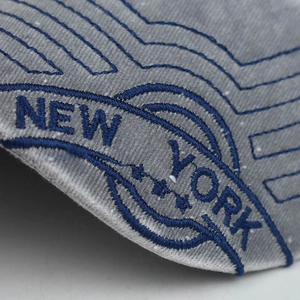 Macro detail of NEW YORK embroidery and star stitching on gray cotton baseball cap