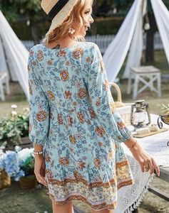 Dettaglio di abito corto floreale bohémien con stampa paisley e balze sul fondo